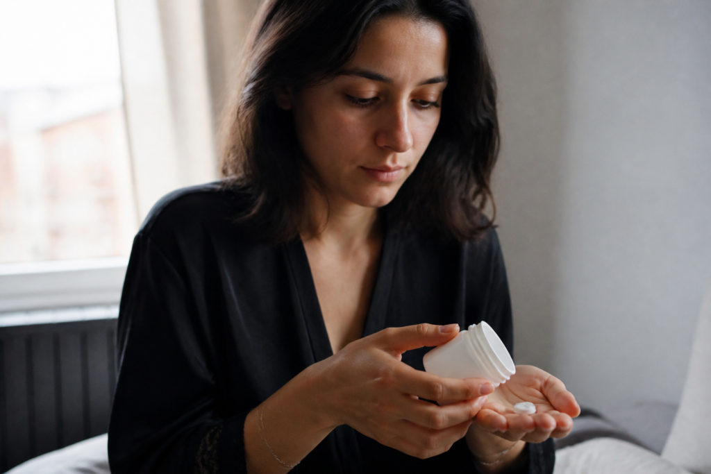 Femme tenant une boite de comprimes blancs