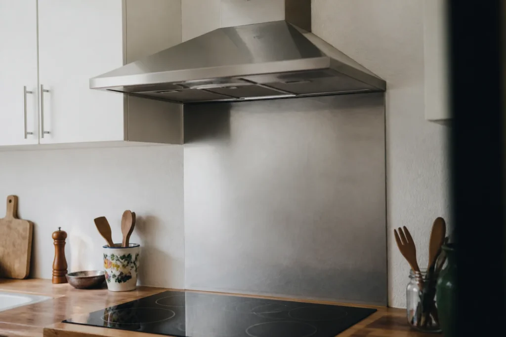 Hotte inox fixee au dessus dune plaque de cuisson