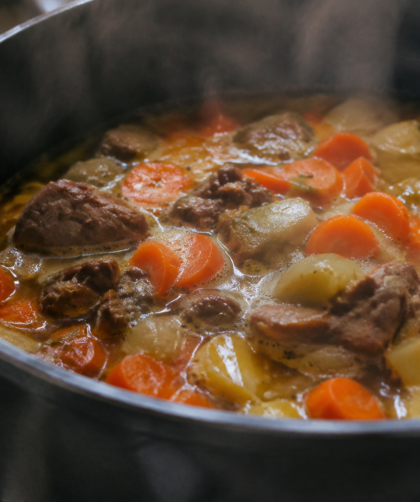 Legumes carottes viande mijotant dans bouillon fumant