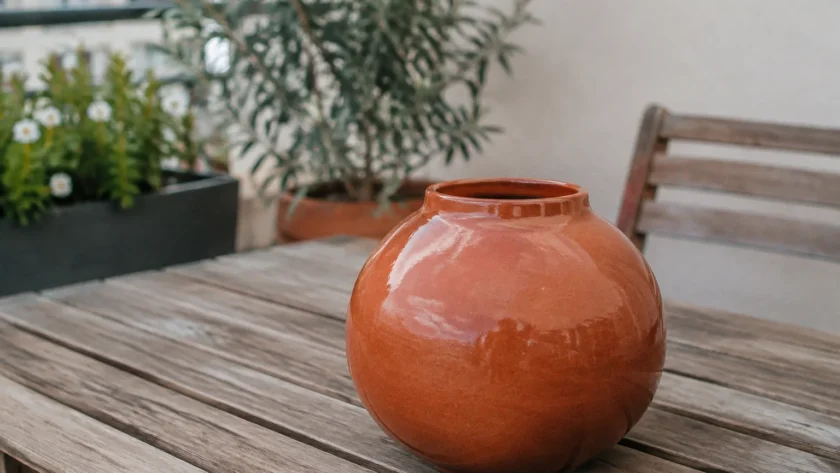 Vase rond orange brique posé sur une terrasse